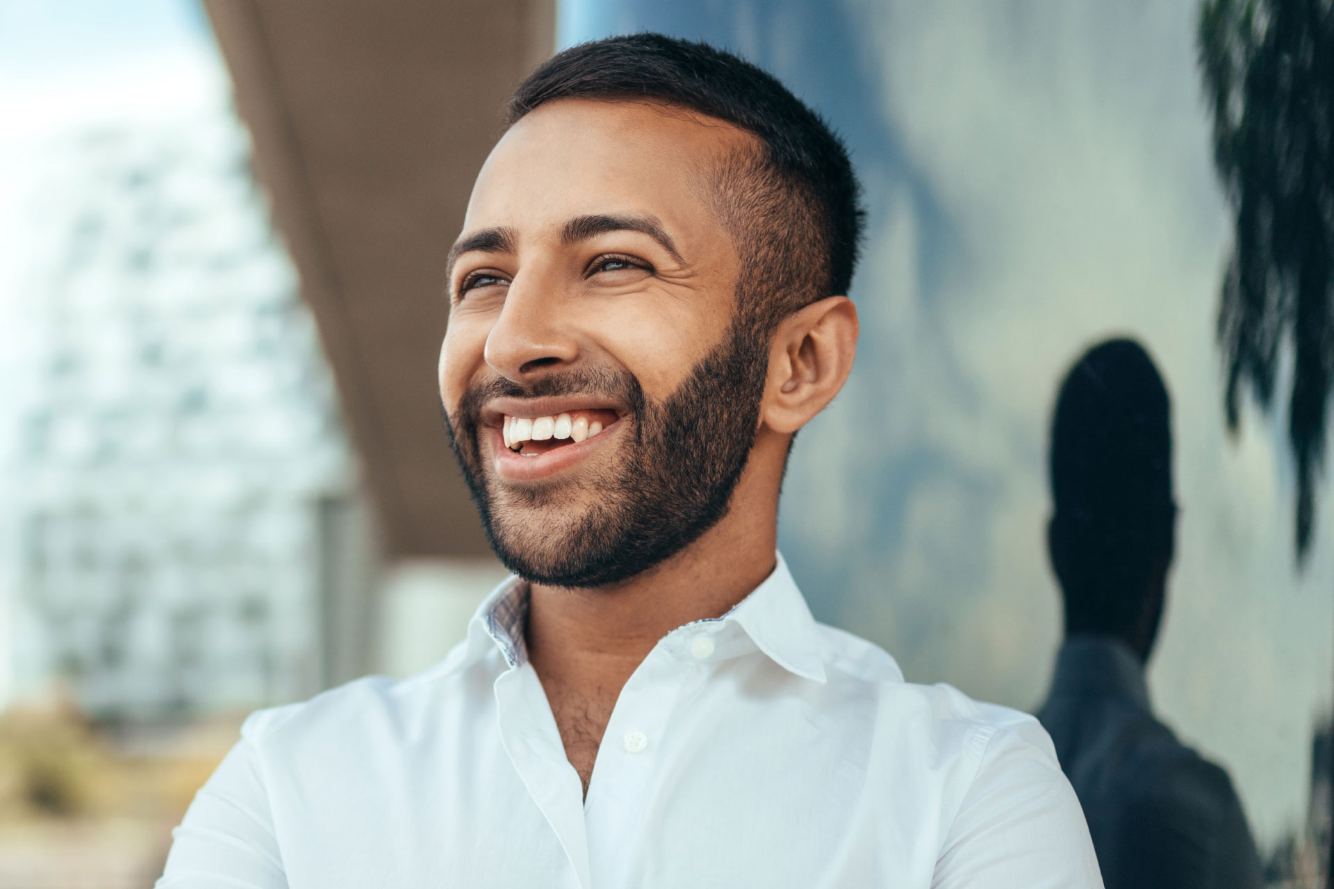 middle-eastern buisness man with beard smiling and looking to the left in the cith